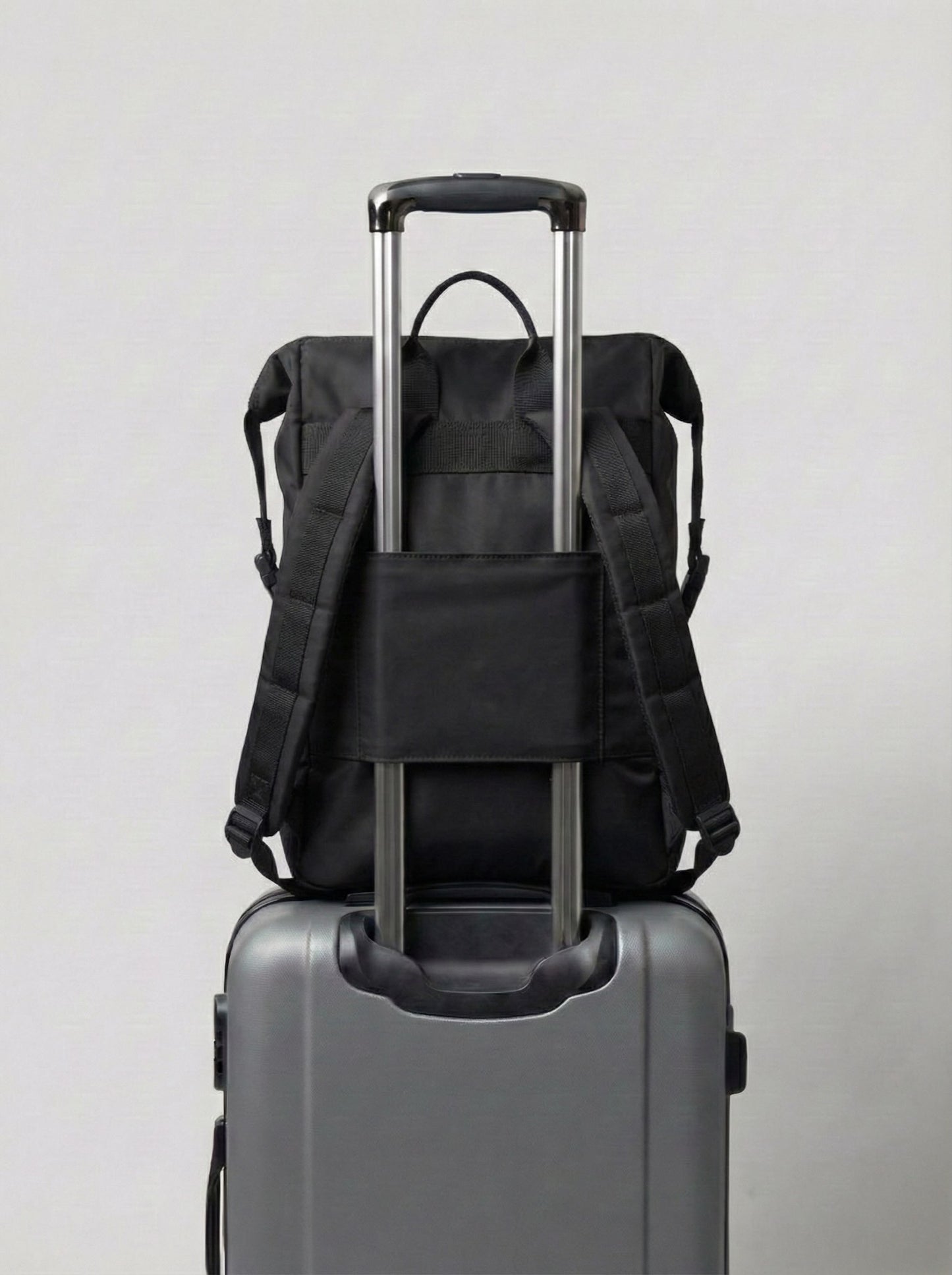 Mochila maternal Cam Bags negra sobre equipaje de viaje vista trasera