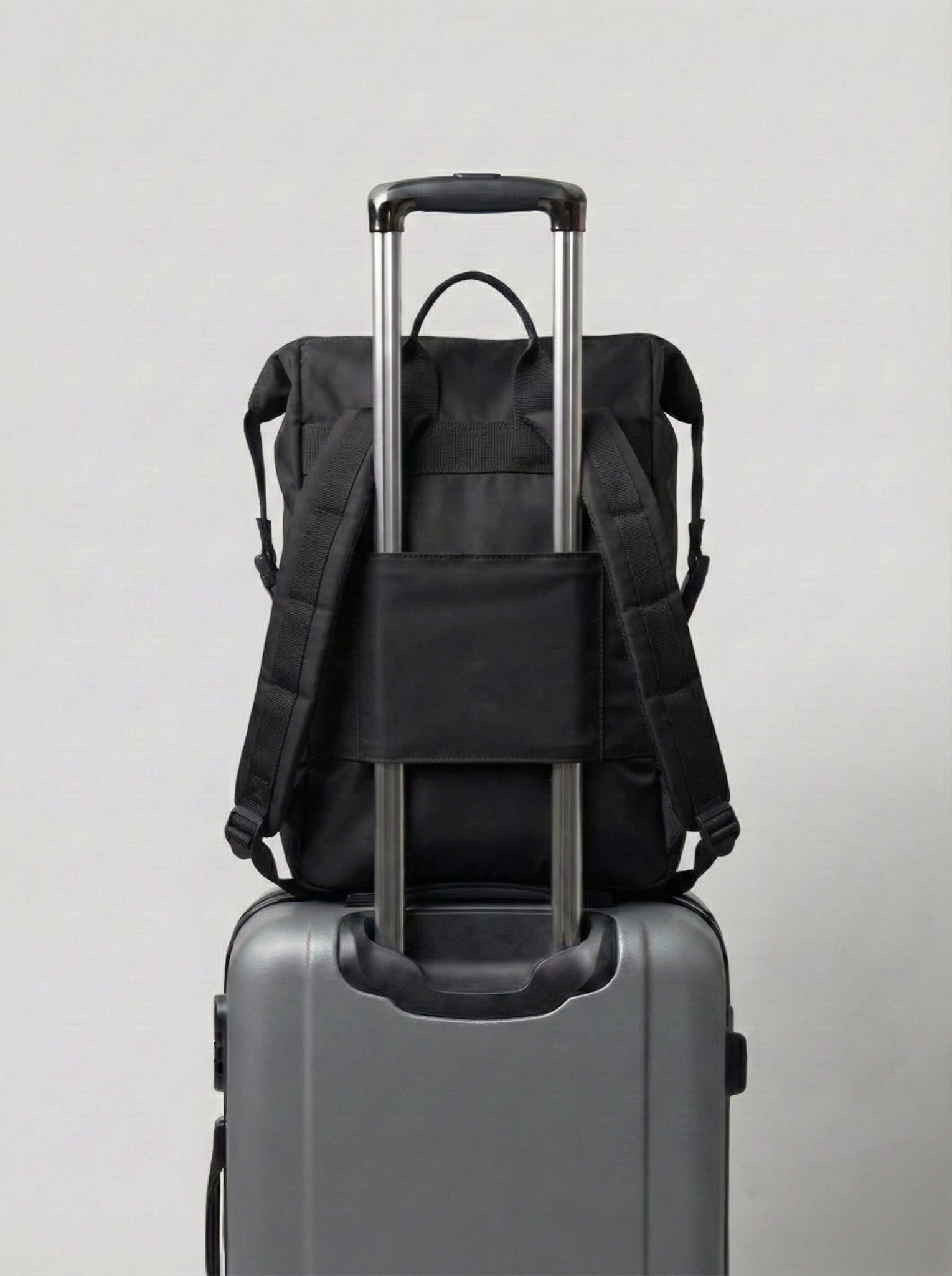 Mochila maternal Cam Bags negra sobre equipaje de viaje vista trasera